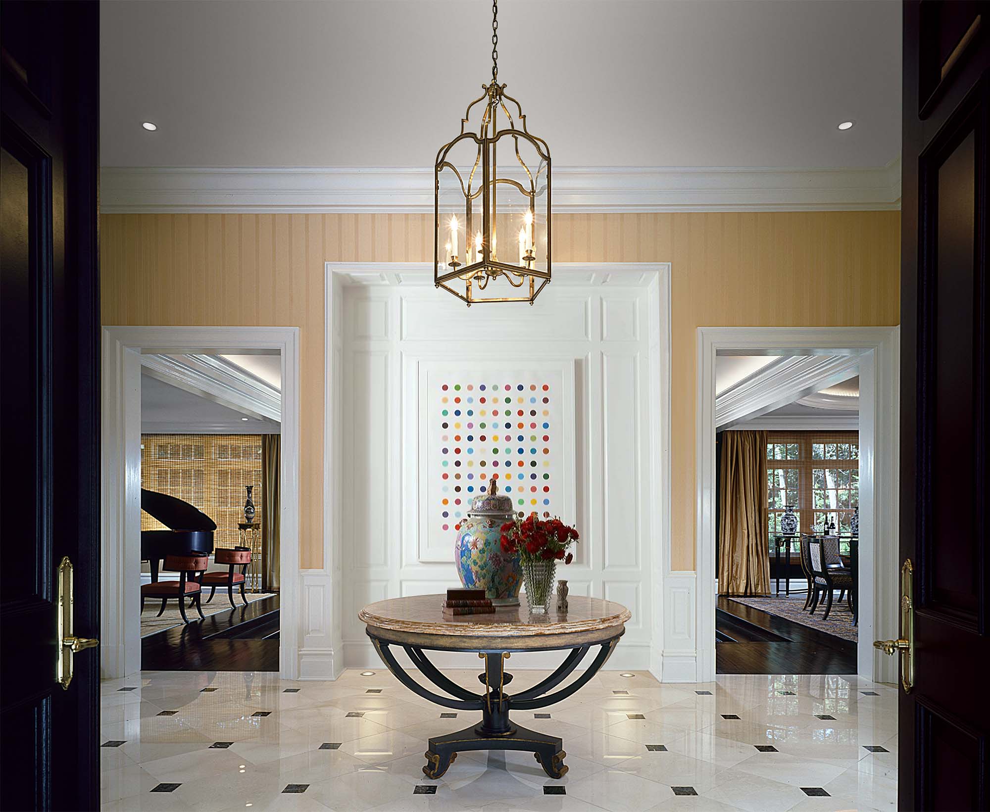 Entry Foyer with Damien Hirst art traditional millwork gold wallpaper dining room piano tile floor