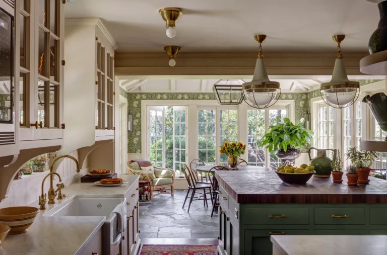 Kitchen interior with marble counters, farmhouse sink, pendant lights, and dining area