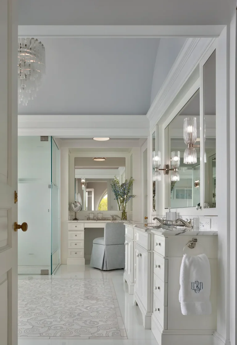 Primary bathroom vanity area with white cabinetry and marble counters in a Huntington Bay waterfront home.