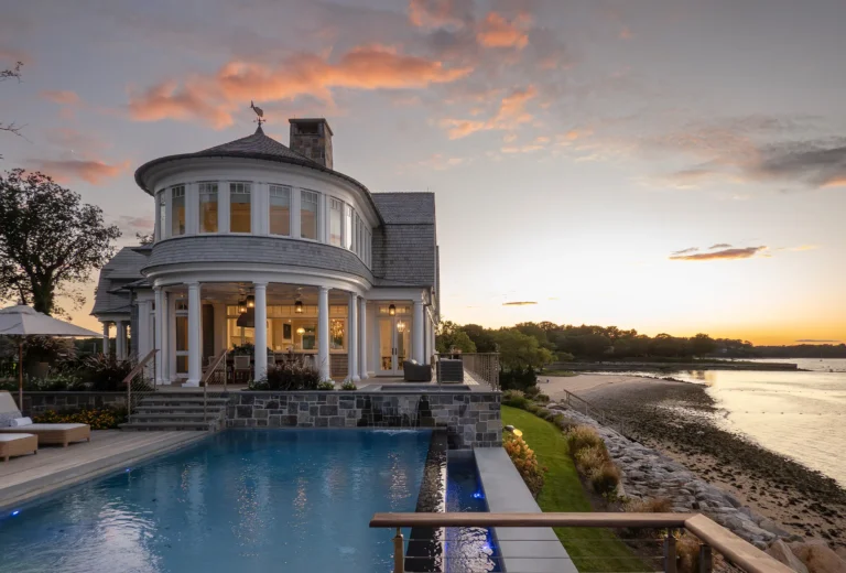 Pool terrace and stone patio overlooking Huntington Bay at sunset.