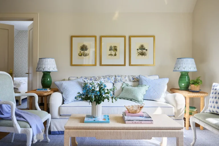 Mother-in-law suite sitting area with pale sofa, green lamps, framed botanical art, and soft natural light